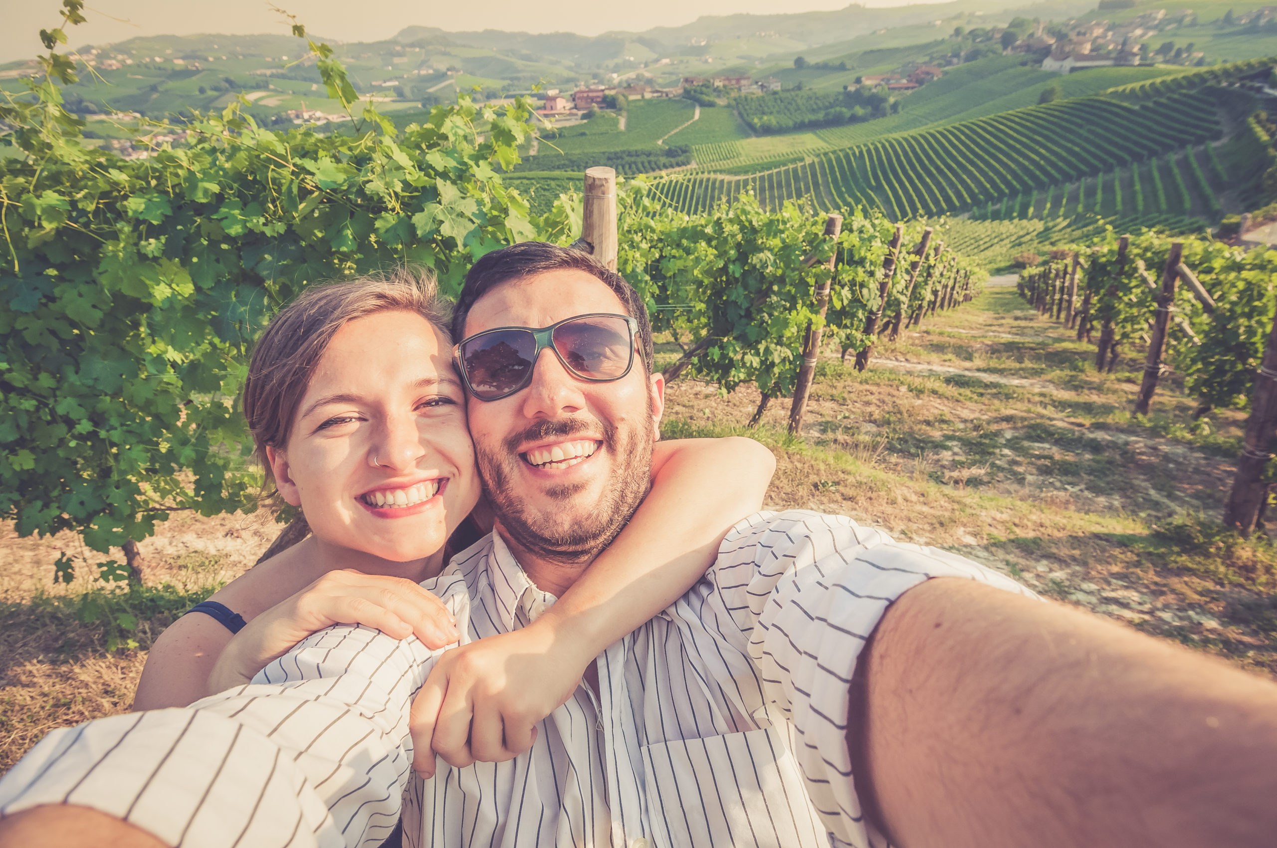 Happy Smiling Handsome Couple Visiting Vineyard Area and Taking Photo